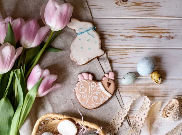 Beautiful Easter composition of eggs with natural colors, gingerbread, flowers, feathers. Holiday content.