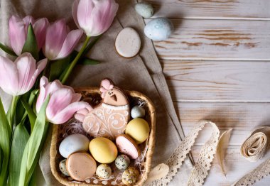 Doğal renklerde yumurtaların, zencefilli ekmeklerin, çiçeklerin, tüylerin güzel Paskalya kompozisyonu. Tatil içeriği.