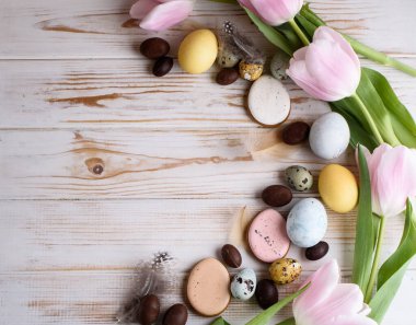 Doğal renklerde yumurtaların, zencefilli ekmeklerin, çiçeklerin, tüylerin güzel Paskalya kompozisyonu. Tatil içeriği.