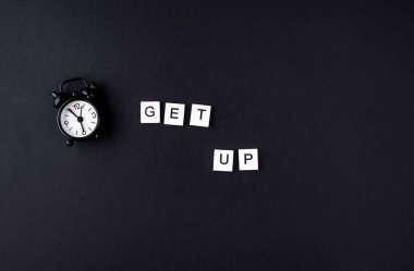 Siyah arka planda siyah alarmlı saat. Yukarıdan görüntüle.