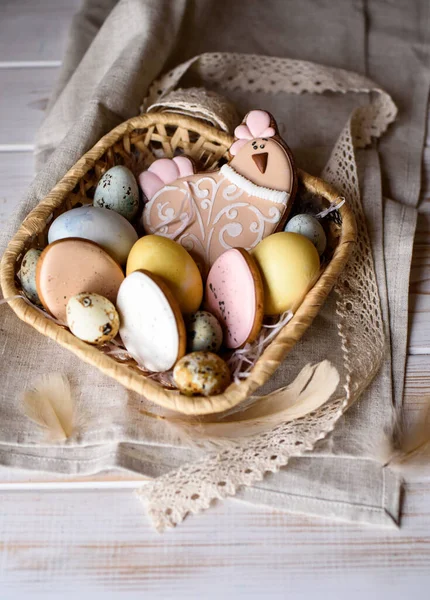 Beautiful Easter composition of eggs with natural colors, gingerbread, flowers, feathers. Holiday content.