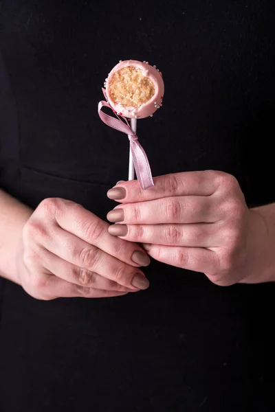 Торт Попадает Руки Женщин Черном Фоне Десерт Розовом Шоколадном Креме — стоковое фото