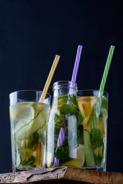 Meyve içeceklerini limonla, nane şekeriyle cam şişelerde şeftali ve masada tüpler ile tazelemek. Yaz içecekleri