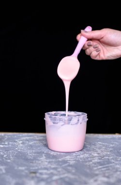 Tatlılar için sütlü çilek kreması. Pasta şefinin ellerinde silikon spatula ile sıvı çikolata kreması..