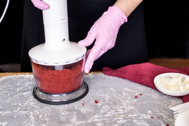 Pasta şefi çubuğun üzerinde kırmızı kadife çikolatalı bir pasta ile tatlı hazırlıyor. Kek patlakları