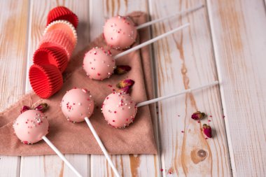 Çubukta tatlı. Ahşap zemin üzerine serpiştirilmiş pembe kek. Lezzetli yemek.