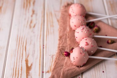 Çubukta tatlı. Ahşap zemin üzerine serpiştirilmiş pembe kek. Lezzetli yemek.