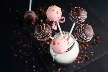 Kaykay tahtasındaki şeker kavanozunda farklı krema ve dekorasyonla bir buket tatlı. Lezzetli yemek.