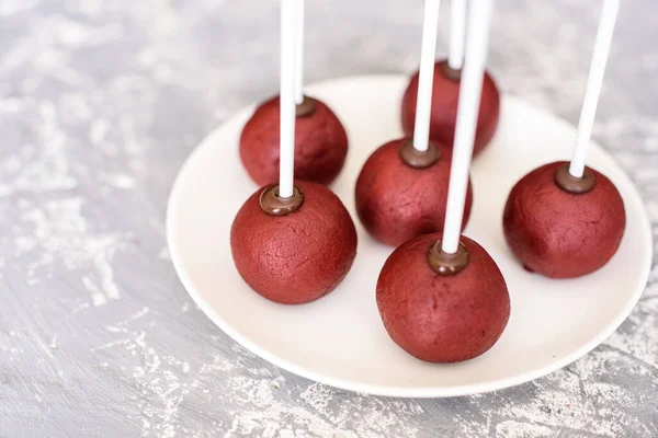 Pasta şefi çubuğun üzerinde kırmızı kadife çikolatalı bir pasta ile tatlı hazırlıyor. Kek patlakları