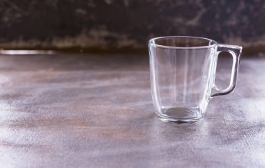 Çay ve kahve için cam bir fincan masanın üzerinde. İçme aletleri