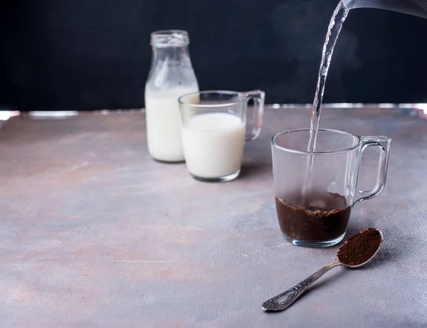 Bardakta kahve yapmak, bir jet sıcak su, şişede süt, kremalı kahve kaşığı. — Stok fotoğraf