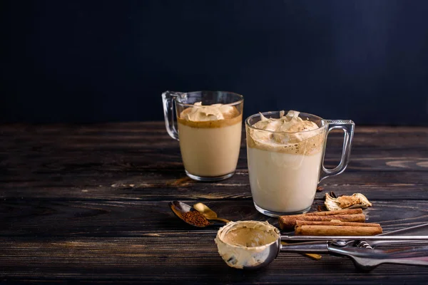 Läckert och väldoftande dalgona kaffe i glas koppar, kanel pinnar, torkade svampar, en sked snabbkaffe, socker. — Stockfoto