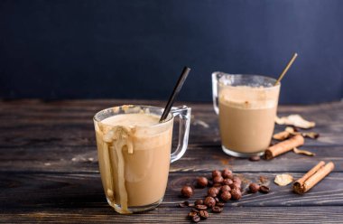 Cam bardaklarda nefis ve kokulu dalgona kahvesi, tarçın çubukları, kurutulmuş mantarlar, bir kaşık hazır kahve, şeker. Sütlü soğuk kahve.