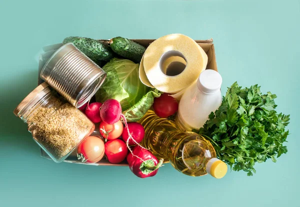 Bir kutu taze sebze, sebze, mısır gevreği, tuvalet kağıdı, tereyağı, kefir, hafif bir arka plan bağışı için. Metin için yer