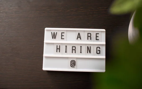 Üzerinde yazı olan ışıklı kutu. Ahşap bir arkaplan kiralıyoruz. Kavram.