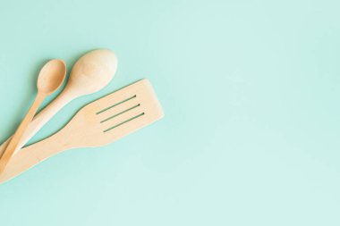 Ahşap bir spatula ve hafif arka planda pişirmek için kaşıklar. Ahşap kaplar.