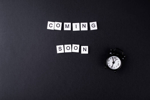 Скоро выйдет из маленьких деревянных кубиков на черном фоне. Место для надписей
