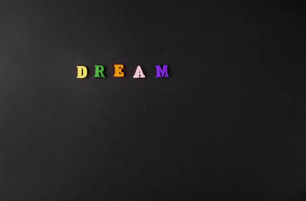 Das Wort Traum Aus Farbigen Holzbuchstaben Steht Auf Schwarzem Hintergrund — Stockfoto