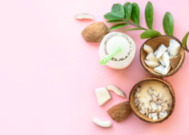 Parça parça hindistan cevizi, pembe arka planda hindistan cevizi talaşı. Yukarıdan bak. Metin için yer.