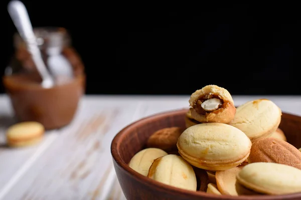 Nueces rusas caseras con leche condensada sobre un fondo claro, servilleta de oblea. Cortar las nueces con leche condensada. Frutos secos condensados — Foto de Stock