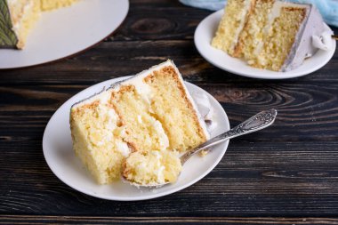 Hindistan cevizi döllenmiş lezzetli bisküvi pastası, ananas dilimleri, kesilmiş. Pasta beyaz tabakta, masanın üstünde. Yukarıdan bak. Tatlı nefis.