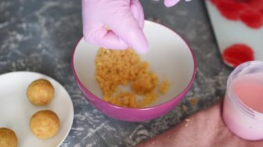 Pembe eldivenli bir pasta şefi tatlı olarak bir bisküvi paylaşır. Bir tatlı yaratma süreci