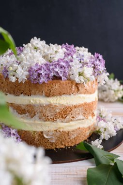 Kremalı bisküvi, hindistan cevizi ve ananasla hamile bırakılmış, leylak çiçekleriyle süslenmiş. Lezzetli tatlı, yemek fotoğrafı..