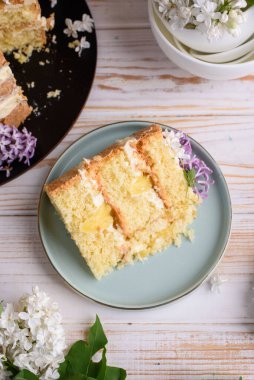 Kremalı bisküvi, hindistan cevizi ve ananasla hamile bırakılmış, leylak çiçekleriyle süslenmiş. Lezzetli tatlı, yemek fotoğrafı..
