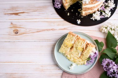 Kremalı bisküvi, hindistan cevizi ve ananasla hamile bırakılmış, leylak çiçekleriyle süslenmiş. Lezzetli tatlı, yemek fotoğrafı..
