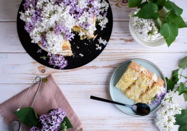 Kremalı bisküvi, hindistan cevizi ve ananasla hamile bırakılmış, leylak çiçekleriyle süslenmiş. Lezzetli tatlı, yemek fotoğrafı..