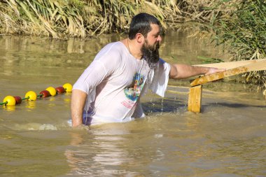 Orta yaşlı Hacı Ürdün Nehri'nde vaftiz geçer