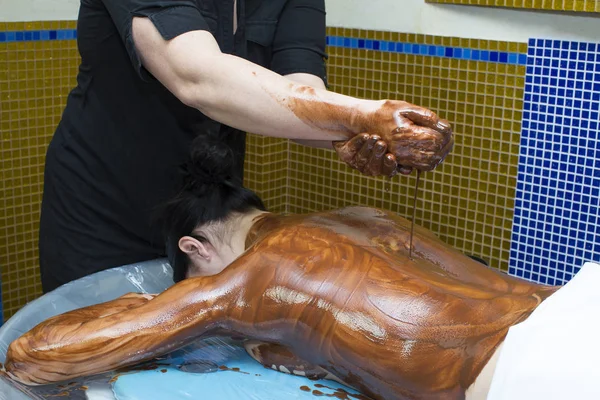 Mulher durante o procedimento de massagem de chocolate café — Fotografia de Stock