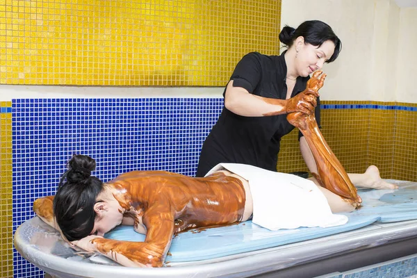 Mujer durante el procedimiento de masaje de chocolate café —  Fotos de Stock