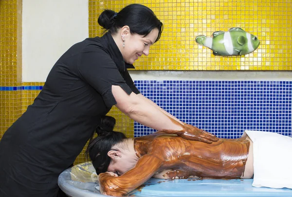 Kobieta podczas procedury masaż czekoladowy kawy — Zdjęcie stockowe