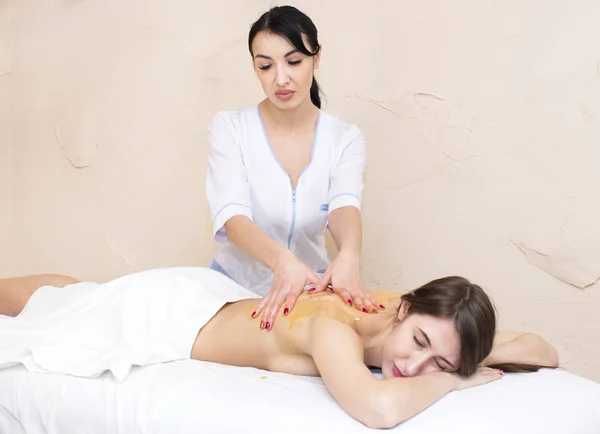 Chica tratamiento masaje miel cuerpo envoltura —  Fotos de Stock