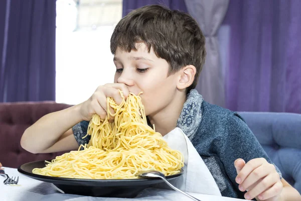 El chico es apetitoso come espaguetis —  Fotos de Stock