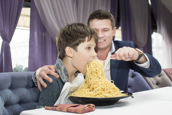 Папа кормит своего сына спагетти — стоковое фото
