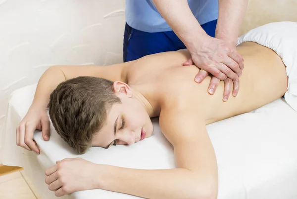 teenager on the procedure of medical medical sports body massage
