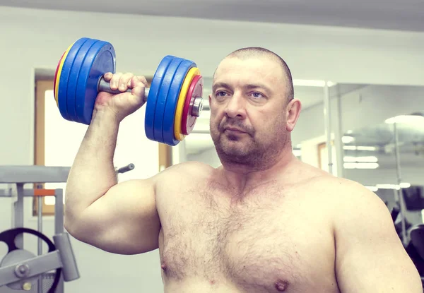 Man is engaged in power bodybuilding in the gym — Stock Photo, Image