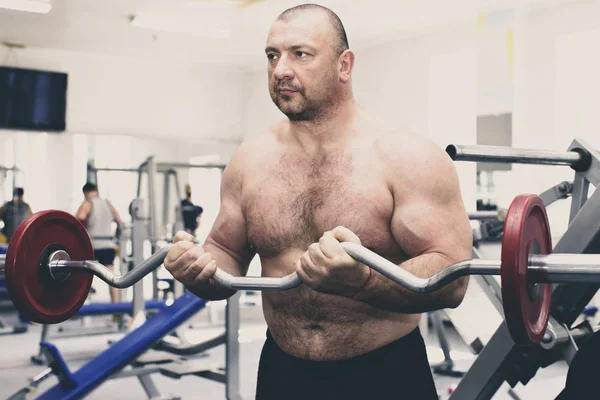 Man is engaged in power bodybuilding in the gym — Stock Photo, Image