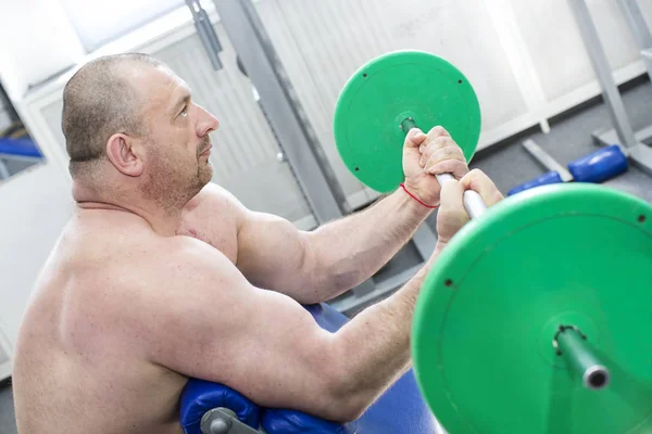 Hombre se dedica a culturismo de potencia en el gimnasio — Foto de Stock