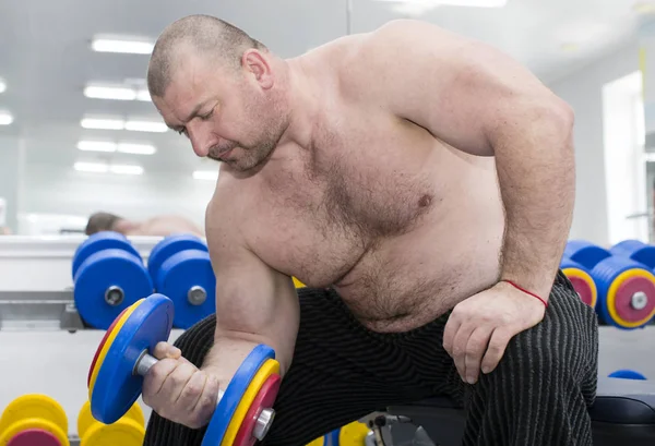 Man is engaged in power bodybuilding in the gym — Stock Photo, Image