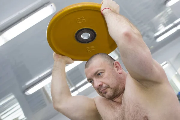 Homme est engagé dans la musculation de puissance dans la salle de gym — Photo
