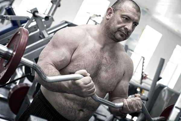 Adult brutal man is engaged in power bodybuilding — Stock Photo, Image