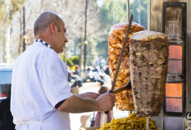 Man cooks Turkish meat kebab at a street cafe clipart