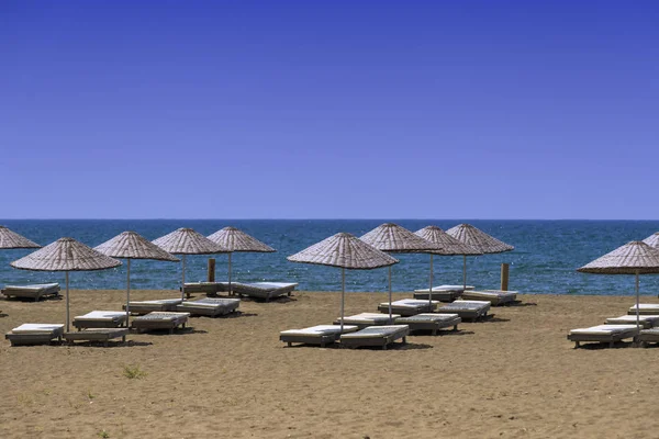 Playa de arena desierta con sombrillas —  Fotos de Stock