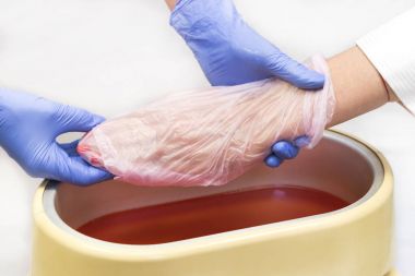 Process paraffin treatment of female hands clipart