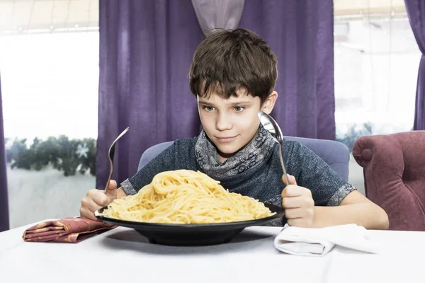 Мальчик аппетит ест большие итальянские спагетти — стоковое фото