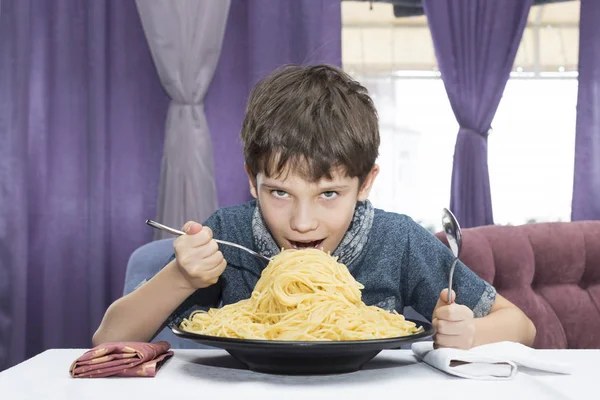 Menino é apetitoso come um grande espaguete italiano — Fotografia de Stock