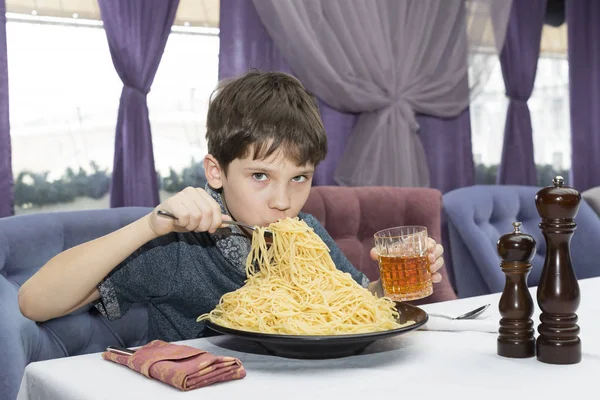 少年は食欲をそそる大きなイタリア スパゲッティを食べる — ストック写真